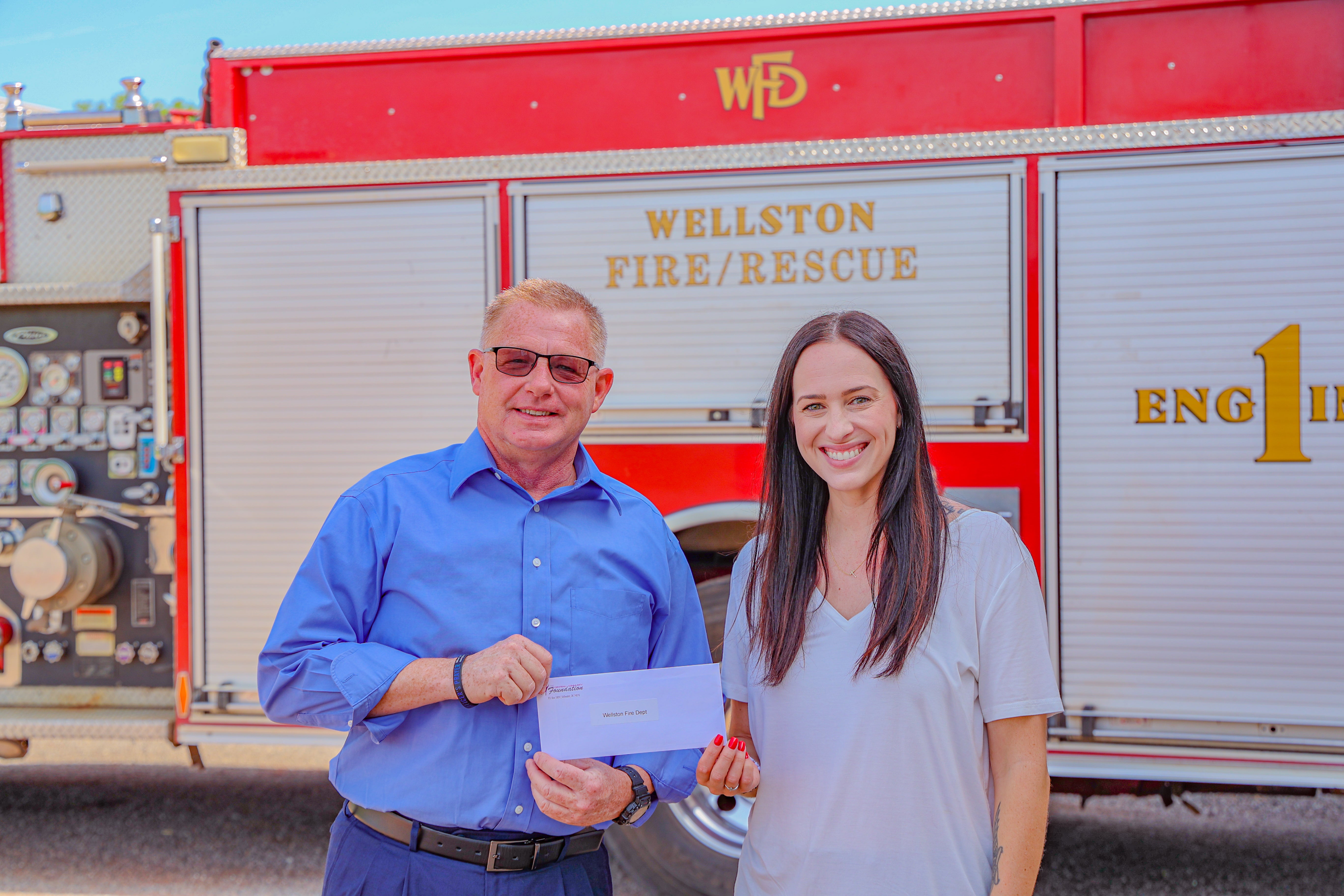 Central Community Foundation coordinator, Erin Talley, presents Todd Beasley, Wellston Fire Department chief with a Central Community Foundation grant.