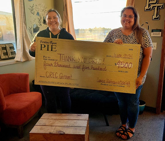 Sarah Axtell (left), PT Partners second vice president, and Sarah Wyatt (right), PT Partners secretary pose thanking the Central Community Foundation.