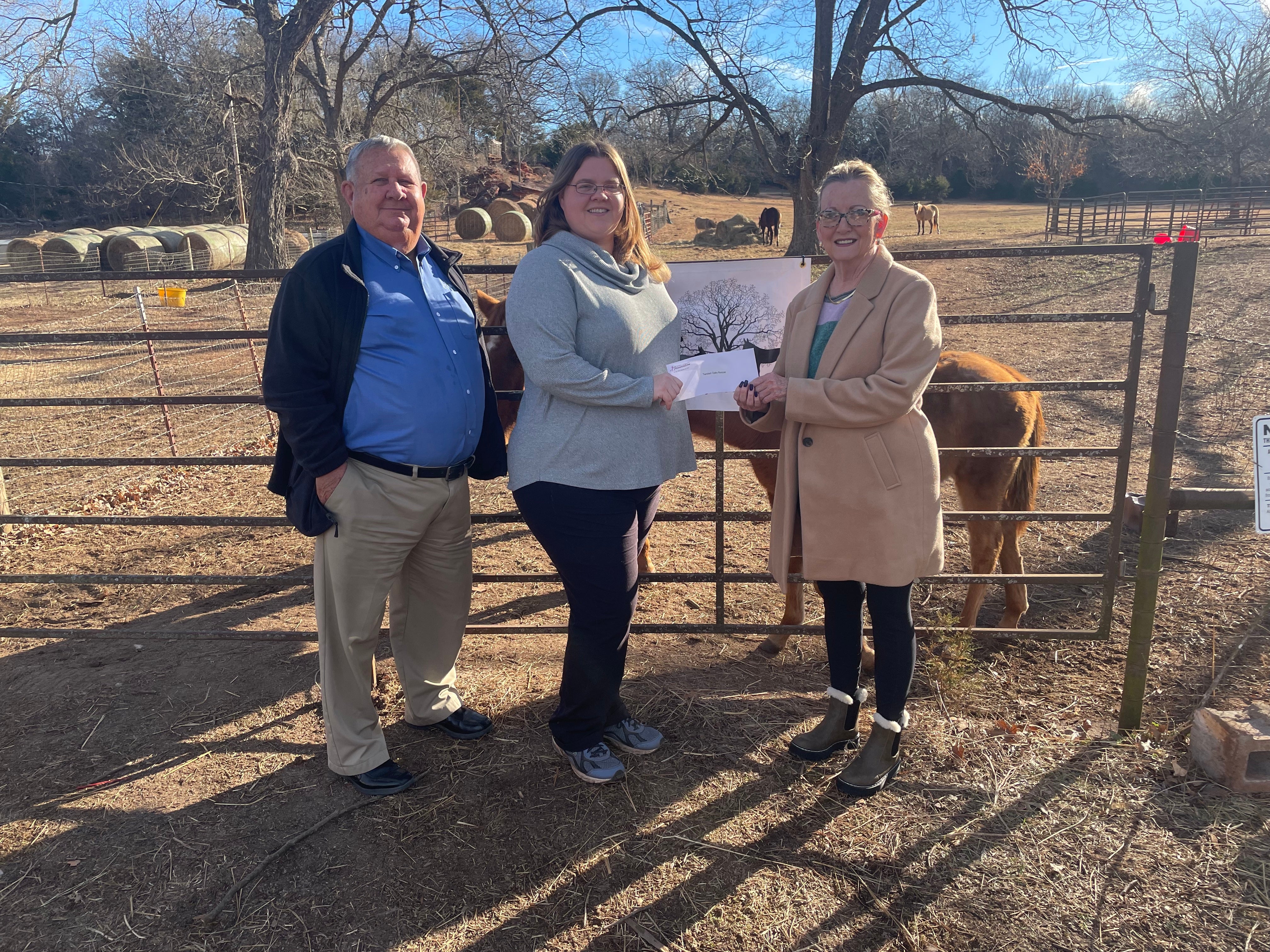 (Bill Davis, Central board member, (left) and Gretchen Harlow, Central Foundation board member, (right) present Twisted Oak Rehab and Rescue’s Alysse Beattie (center) with a grant.