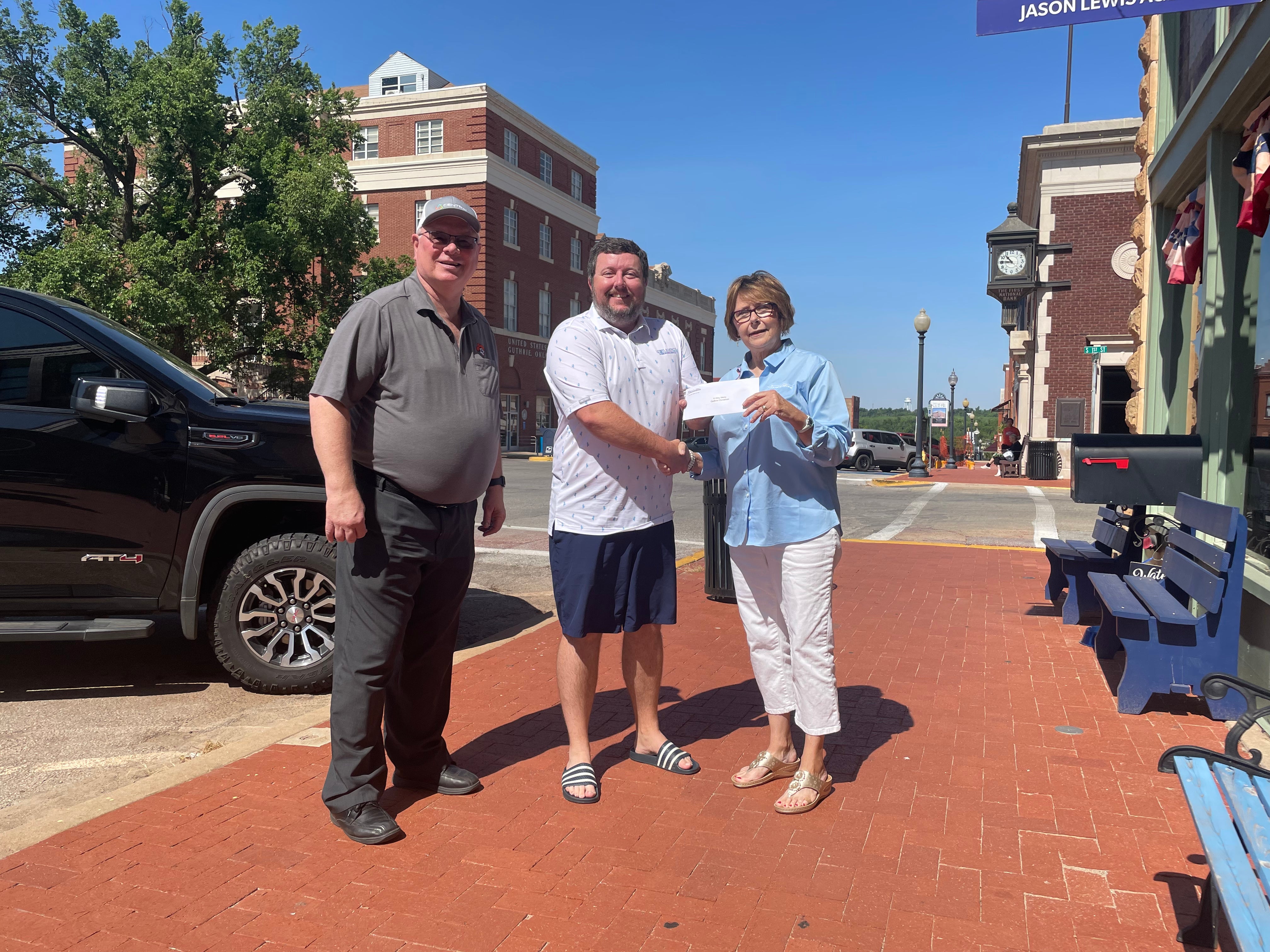 Pictured are Sid Sperry, Central Rural Electric Cooperative board member; Jason Lewis, President of A Very Merry Guthrie Christmas Association; and Janie Carey, Central Community Foundation board member.